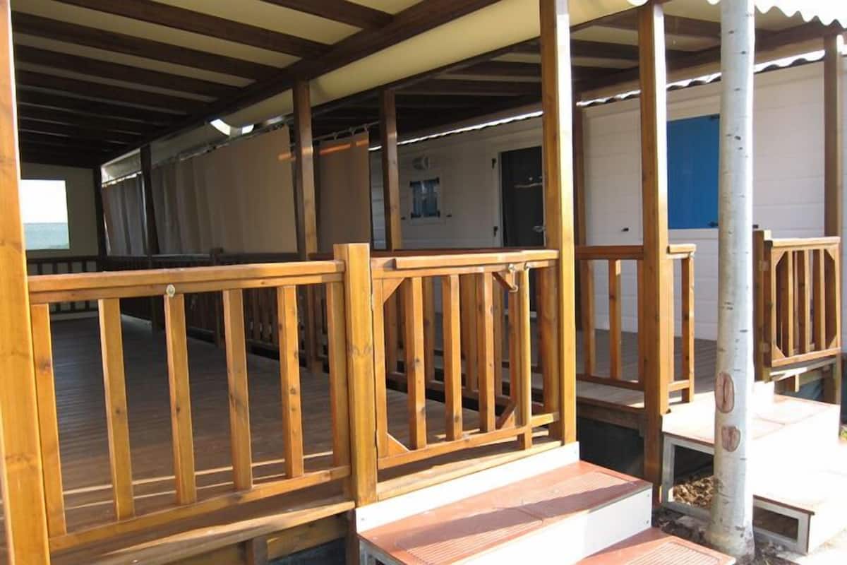 A covered outdoor area with wooden railings and a bench.