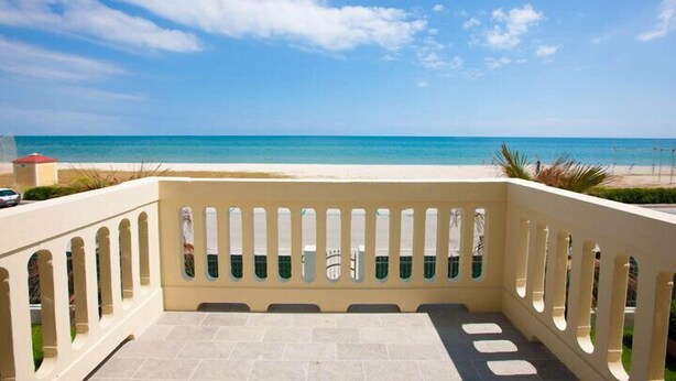 Un balcón con vista a la playa y al océano.