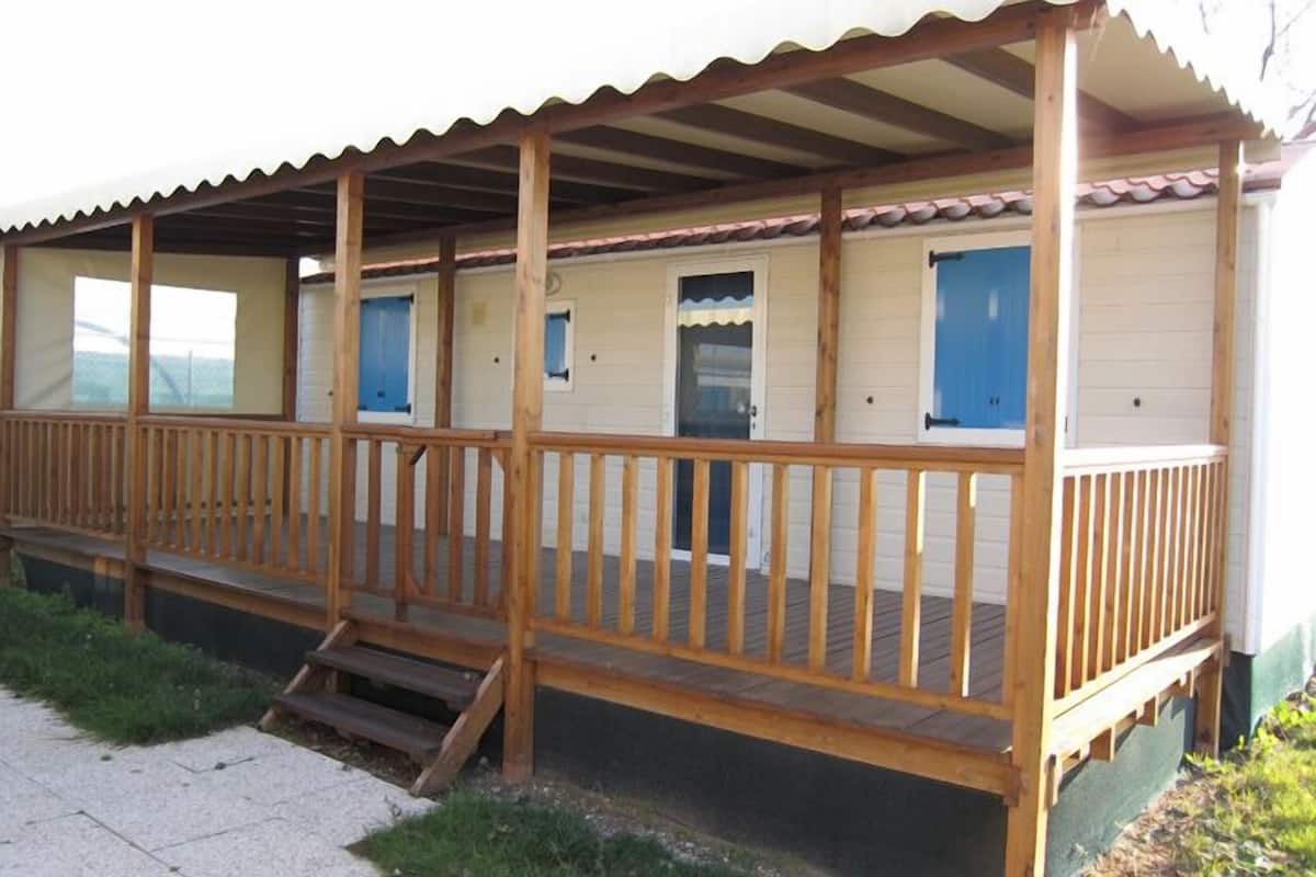 A row of cabins with wooden balconies and a covered porch.