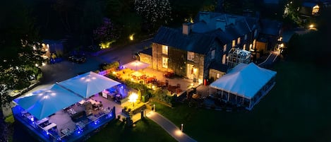 A large estate with a main building, a covered patio, and a tented area.