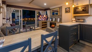 A modern kitchen with a microwave, oven, and wooden cabinets. - Aberdunant Hall (Porthmadog)