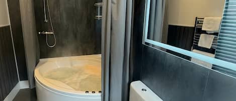 Un baño moderno con bañera, inodoro y lavamanos.