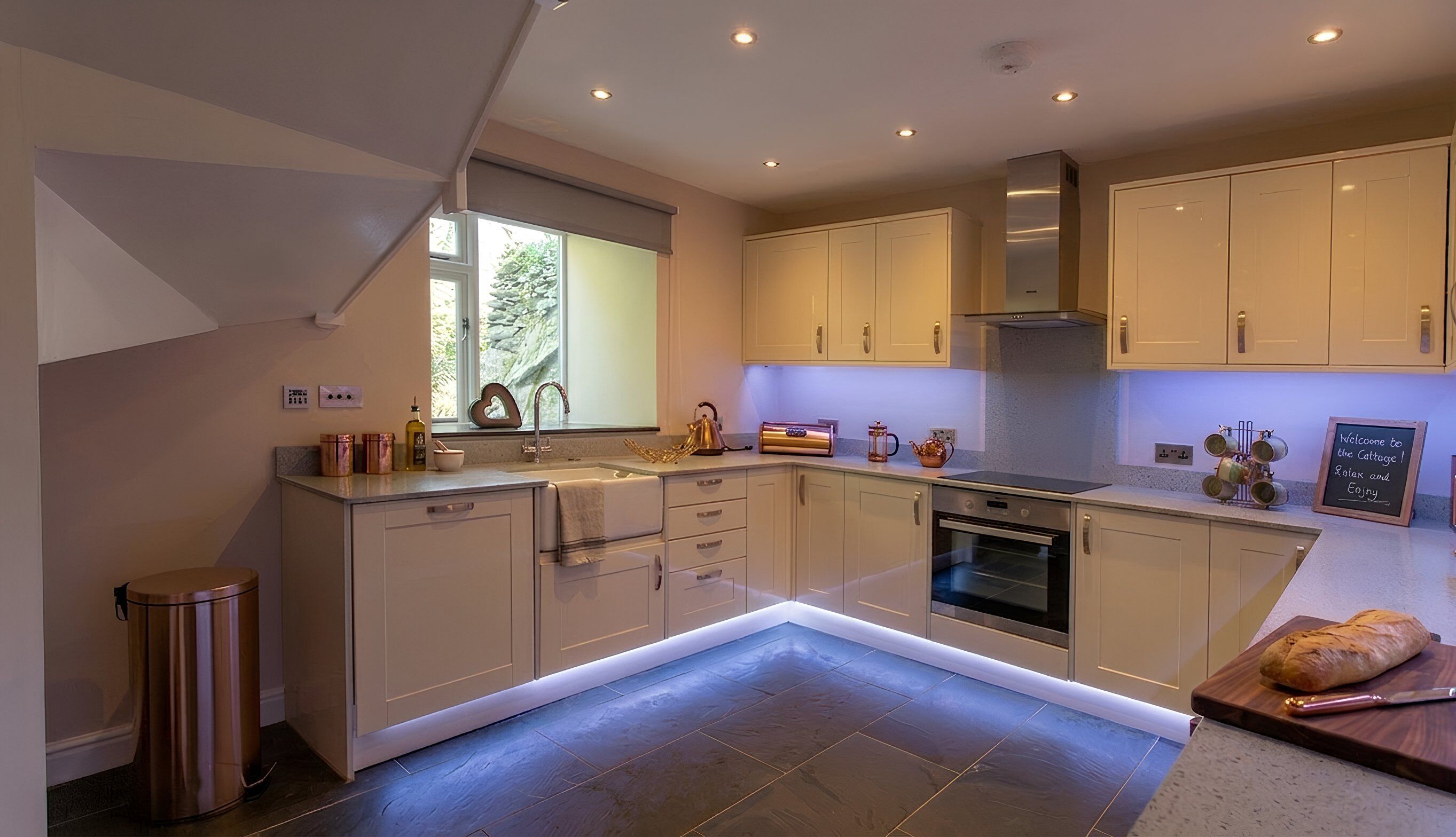 A modern kitchen with a built-in oven, a stainless steel sink, and a large window.