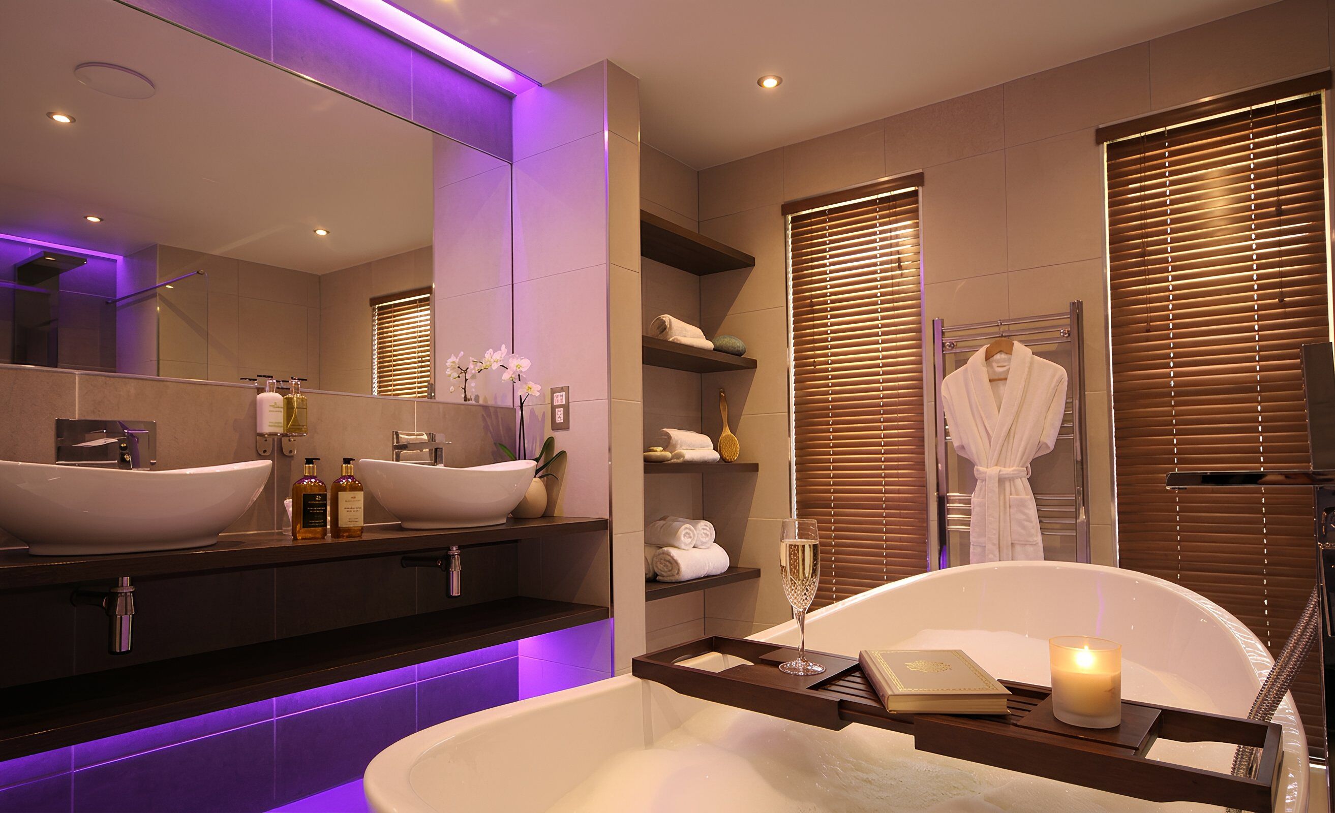 A modern bathroom with a freestanding bathtub, a vanity with a large mirror, and a robe rack.