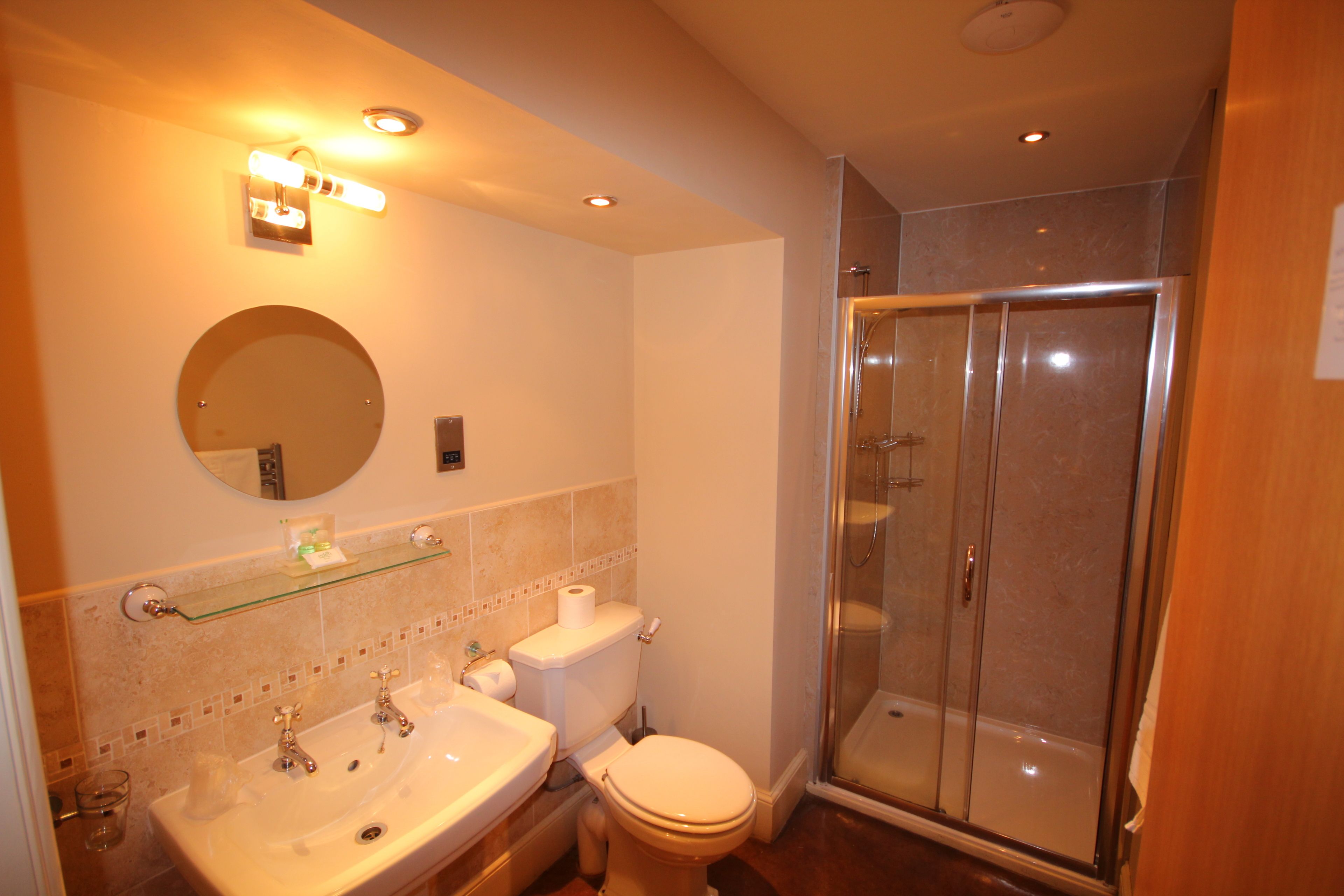 A bathroom with a sink, toilet, and glass-enclosed shower.