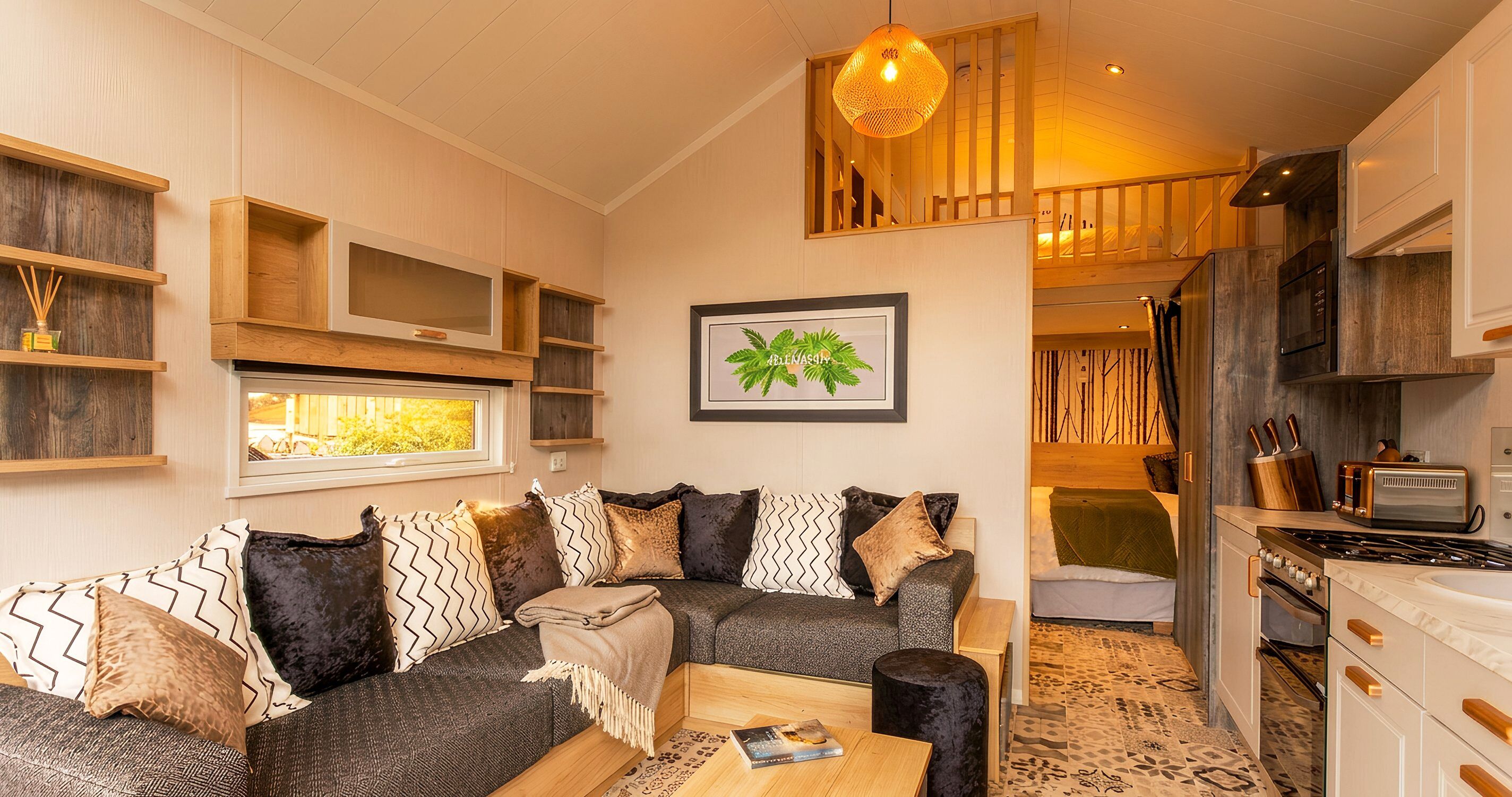 A cozy living area with a sofa, a coffee table, and a kitchen with a stove and cabinets.