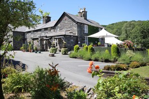 A stone building with a sloped roof and a white tent in the foreground. - Aberdunant Hall (Porthmadog)