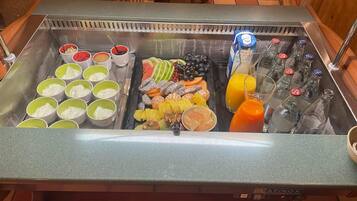 A breakfast bar with various food items and beverages.