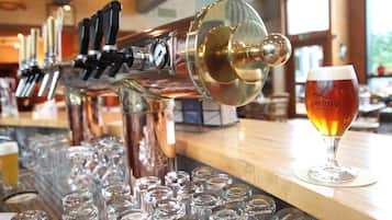 Eine Bar mit mehreren Zapfhähnen und einem Glas Bier auf der Theke.