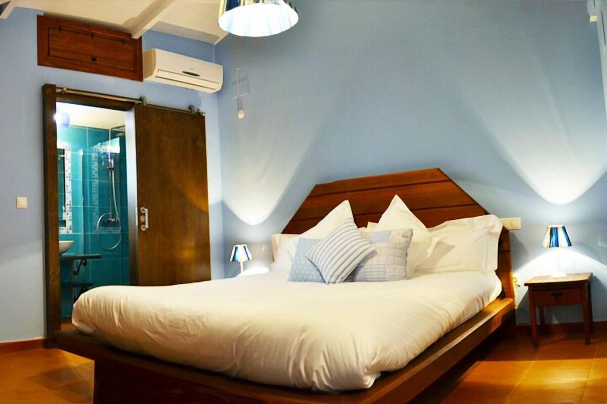 Un dormitorio con cama de madera, una mesita de noche, una lámpara y un armario.