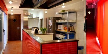 Uma cozinha moderna com painel atrás do fogão vermelho, eletrodomésticos de aço inoxidável e um armário embutido.