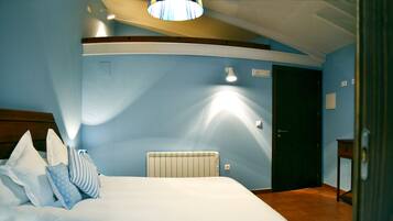 Une chambre à coucher avec un lit, des oreillers, un radiateur et une porte.