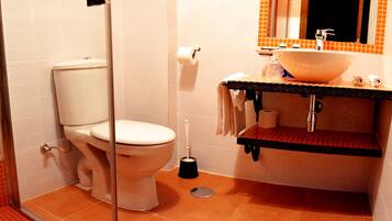 A bathroom with a toilet, sink, and mirror.