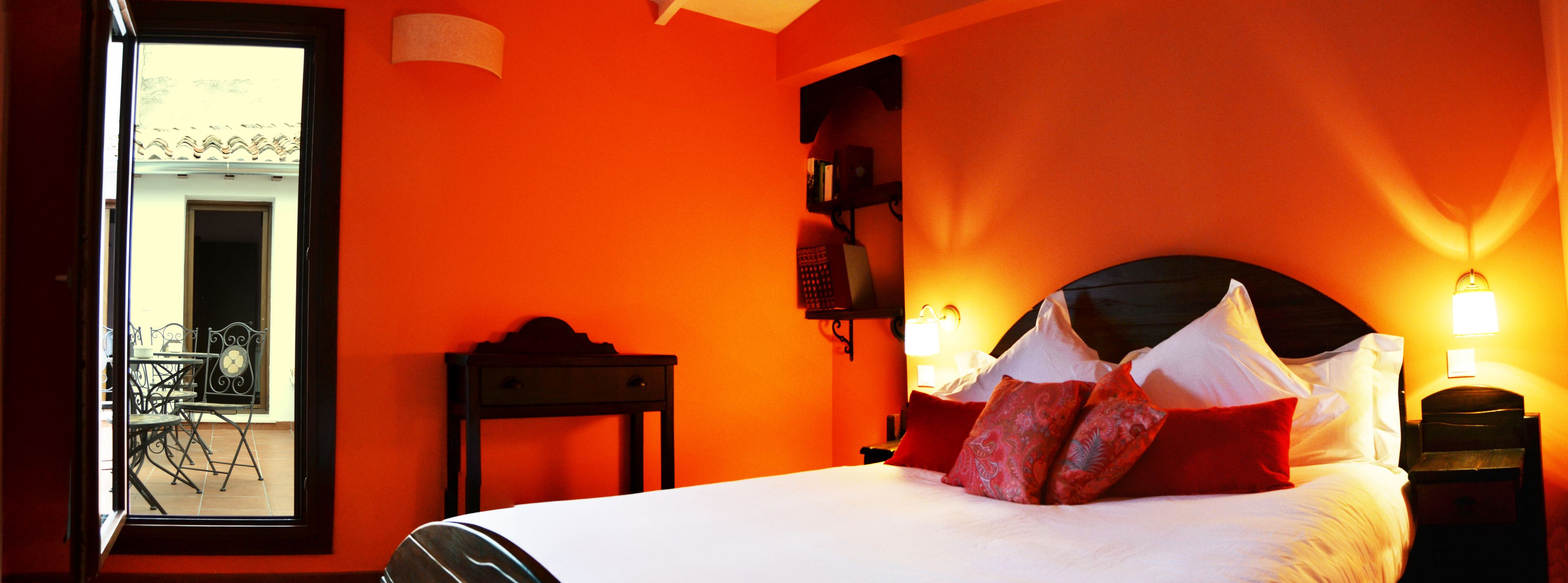 Una habitación de hotel con cama, mesita de noche, silla y ventana.