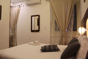 A hotel room with a bed, a mirror, curtains, and a window with a view. - B&B Galleria Frascati (Frascati)