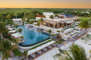 A resort with a large pool, outdoor seating, and a view of the surrounding landscape. - Fairmont Mayakoba Riviera Maya - All Inclusive (Playa del Carmen)