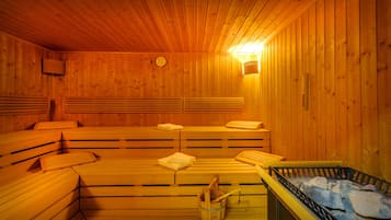 Eine Sauna mit Holzbänken, einem Eimer und einem Steingefäß.