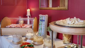 A buffet setup with various food items and a candle on a table. - Hotel Schloss Nebra (Nebra)