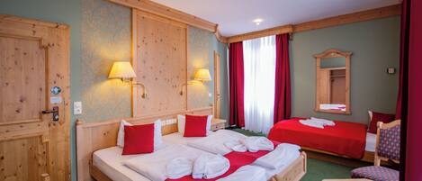 Een hotelkamer met twee bedden, houten hoofdborden en een klein tafeltje.