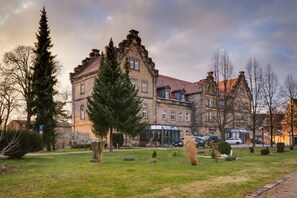 A historic building with a large garden, a conservatory, and a parking area. - Hotel Schloss Nebra (Nebra)