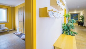 A hotel lobby with yellow walls, a reception desk, a seating area, and a large window. - Hotel Schloss Nebra (Nebra)