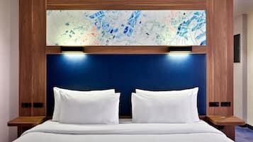 Une chambre d’hôtel avec un grand lit, deux tables de chevet et une carte accrochée au mur.