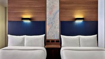 Habitación de hotel con dos camas, un mapa grande en la pared y dos luces fijadas a la pared.