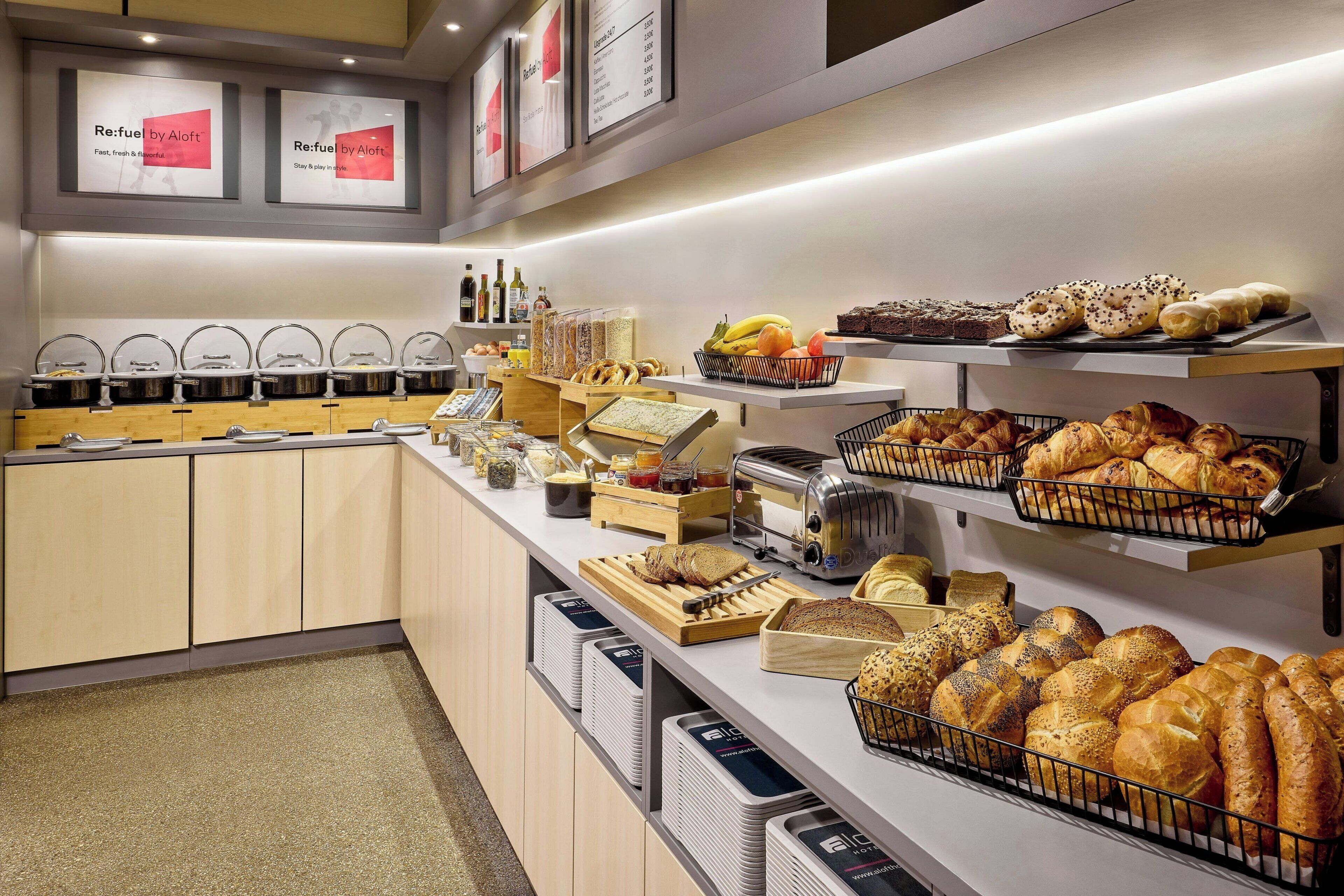 Een ontbijtbuffet met diverse broden, gebak en toevoegingen.