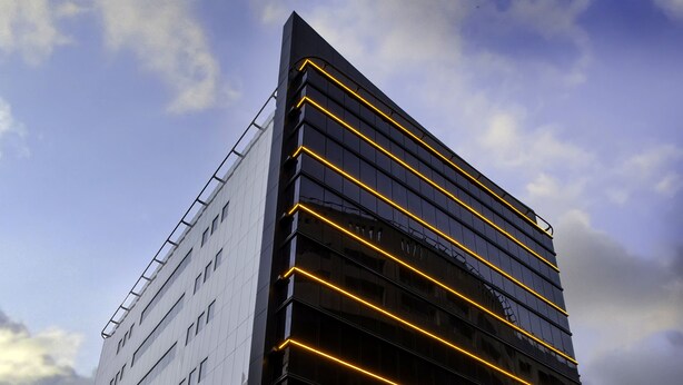 A modern hotel building with a glass facade and illuminated horizontal lines. - Al Sarab Hotel (Dubai)