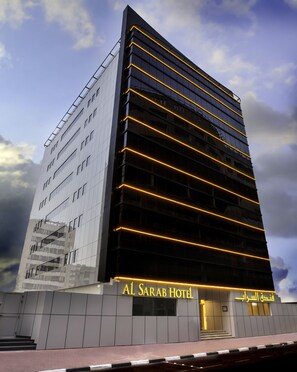 A modern hotel building with a glass facade and illuminated horizontal lines. - Al Sarab Hotel (Dubai)