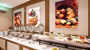 A buffet setup with various food stations and decorative wall art. - Al Sarab Hotel (Dubai)