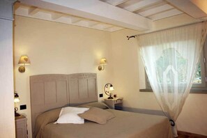 A bedroom with a bed, bedside lamps, a window with sheer curtains, and a nightstand. - La Terrazza di Reggello (Reggello)