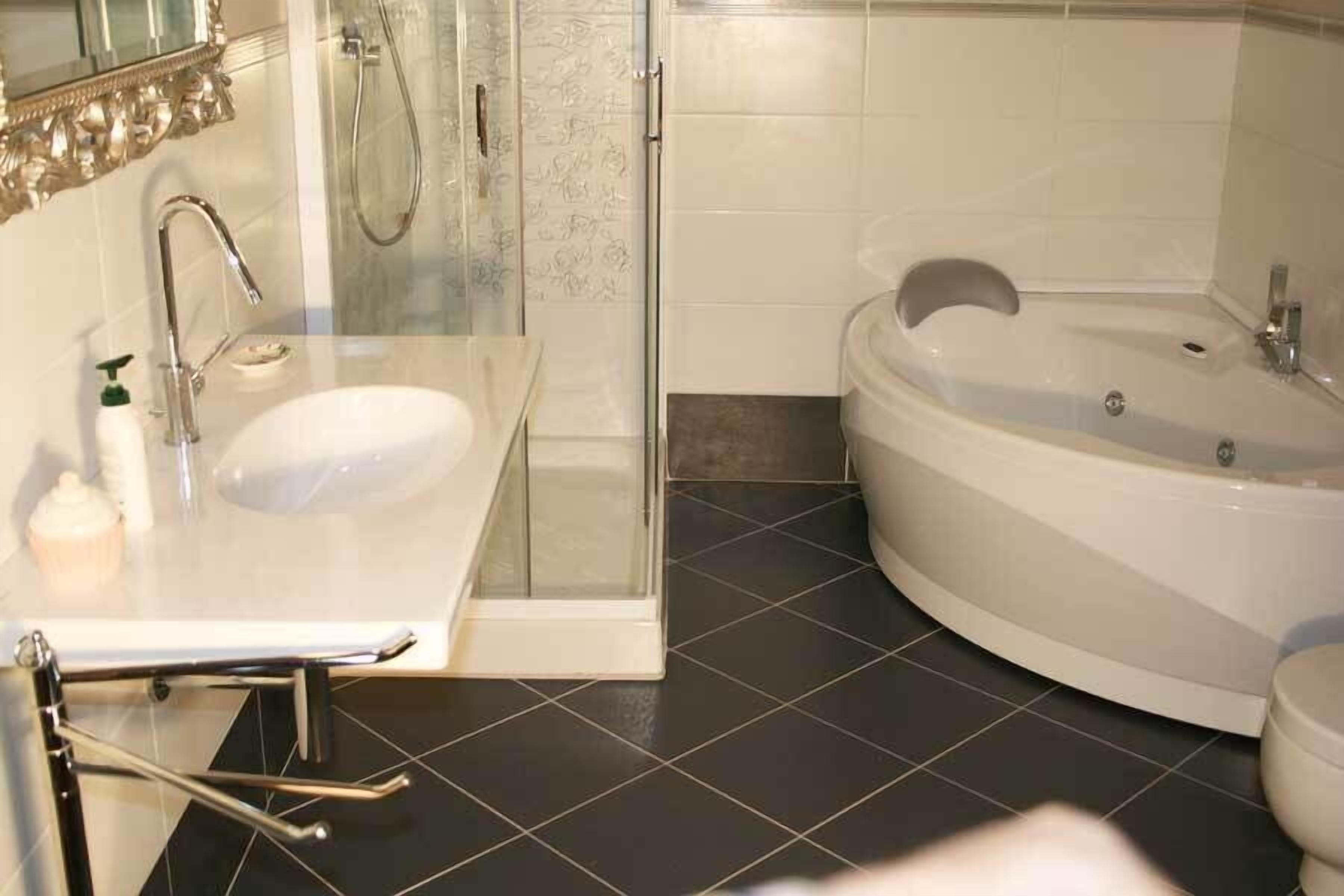 Een moderne badkamer met een douchecabine van glas, een wit wastafelmeubel en een vrijstaand bad.