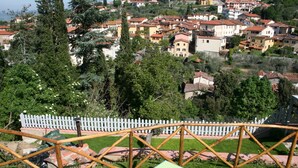 A view of a residential area with houses, trees, and a white picket fence. - La Terrazza di Reggello (Reggello)