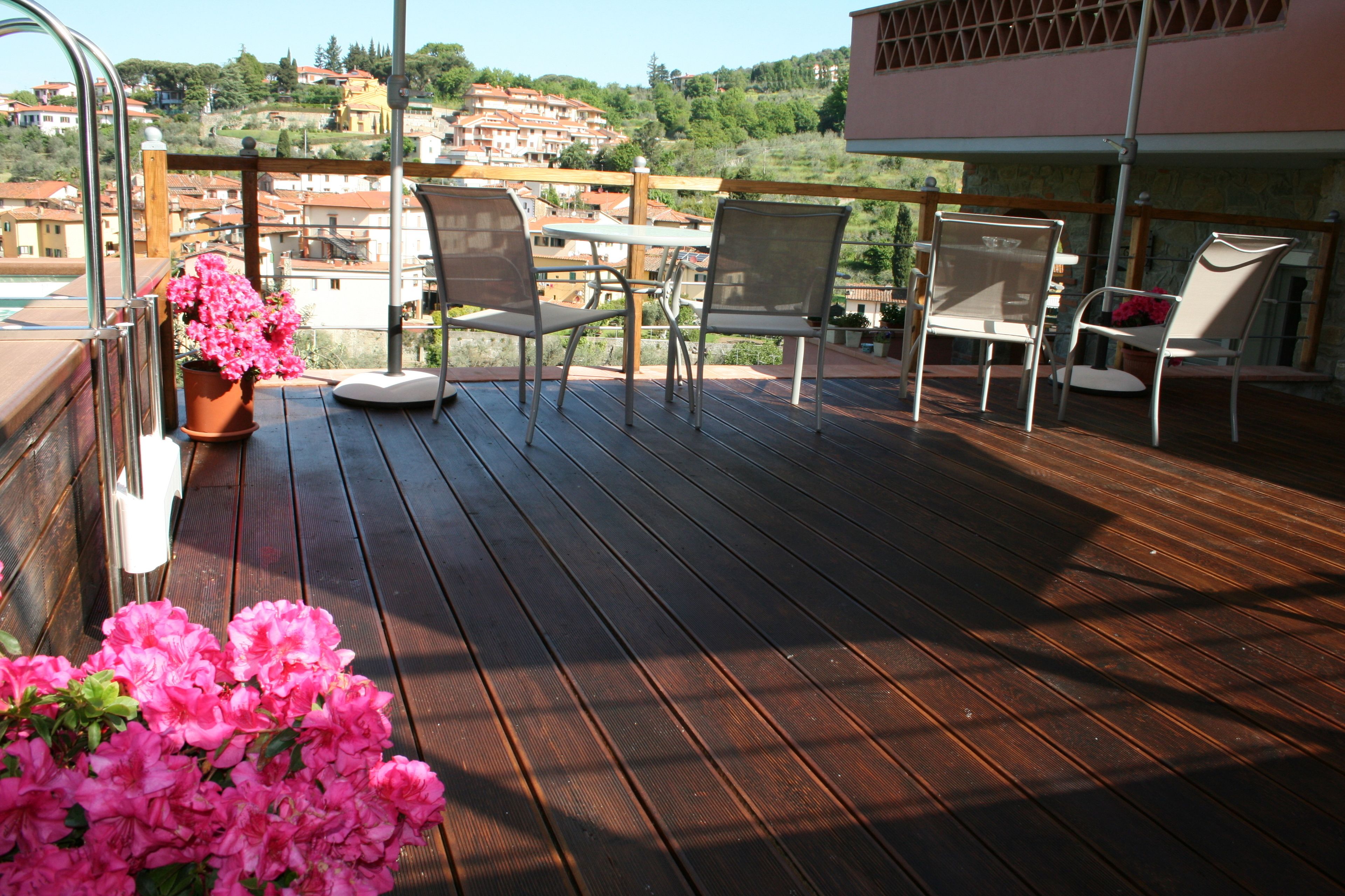A wooden deck with outdoor furniture and a potted plant.