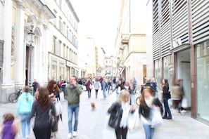 A busy urban street with pedestrians and a dog. - Residenza Cavour (Parma)