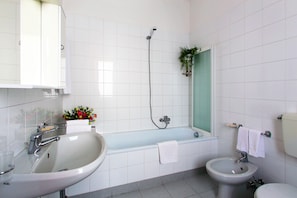 A modern bathroom with a large bathtub, a separate sink, and a toilet. - Residenza Cavour (Parma)