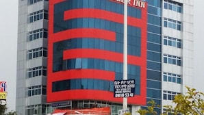 Un hotel con una facciata importante nei colori rosso e blu, con su scritto 'Helzer Inn'.
