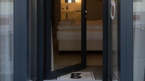 A modern hotel room with a bed, a bedside table, and a mirror. - grätzlhotel Karmelitermarkt (Vienna)