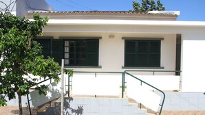 A white building with green shutters, a brick staircase, and a small tree. - Cocoa Hotel Residence São Tomé (São Tomé)