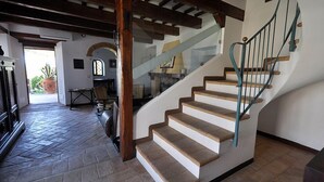 A staircase with wooden steps and a metal railing, leading to an upper floor.