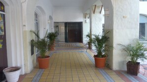 A corridor with tiled flooring, potted plants, and a door at the end. - Casa Diamond (Cabo San Lucas)