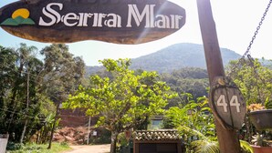 A wooden sign with the text "Serra Mair" and a number "44" on a post. - Serramar Flat (Ubatuba)