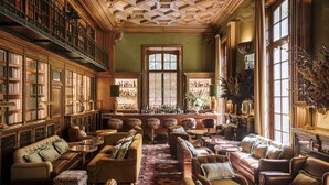 Una biblioteca con estanterías, chimenea y zonas de estar.