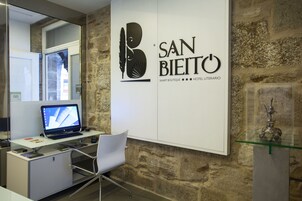 Un espacio de oficina moderno con un escritorio, una silla, una computadora y un objeto decorativo en un estante de vidrio.