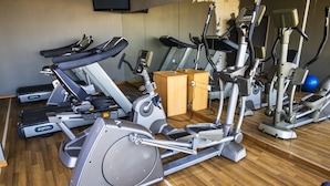 A gym with various exercise machines, including treadmills and stationary bikes, arranged on a wooden floor. - WL Hotel Maputo City Centre Mozambique Collection (Maputo)