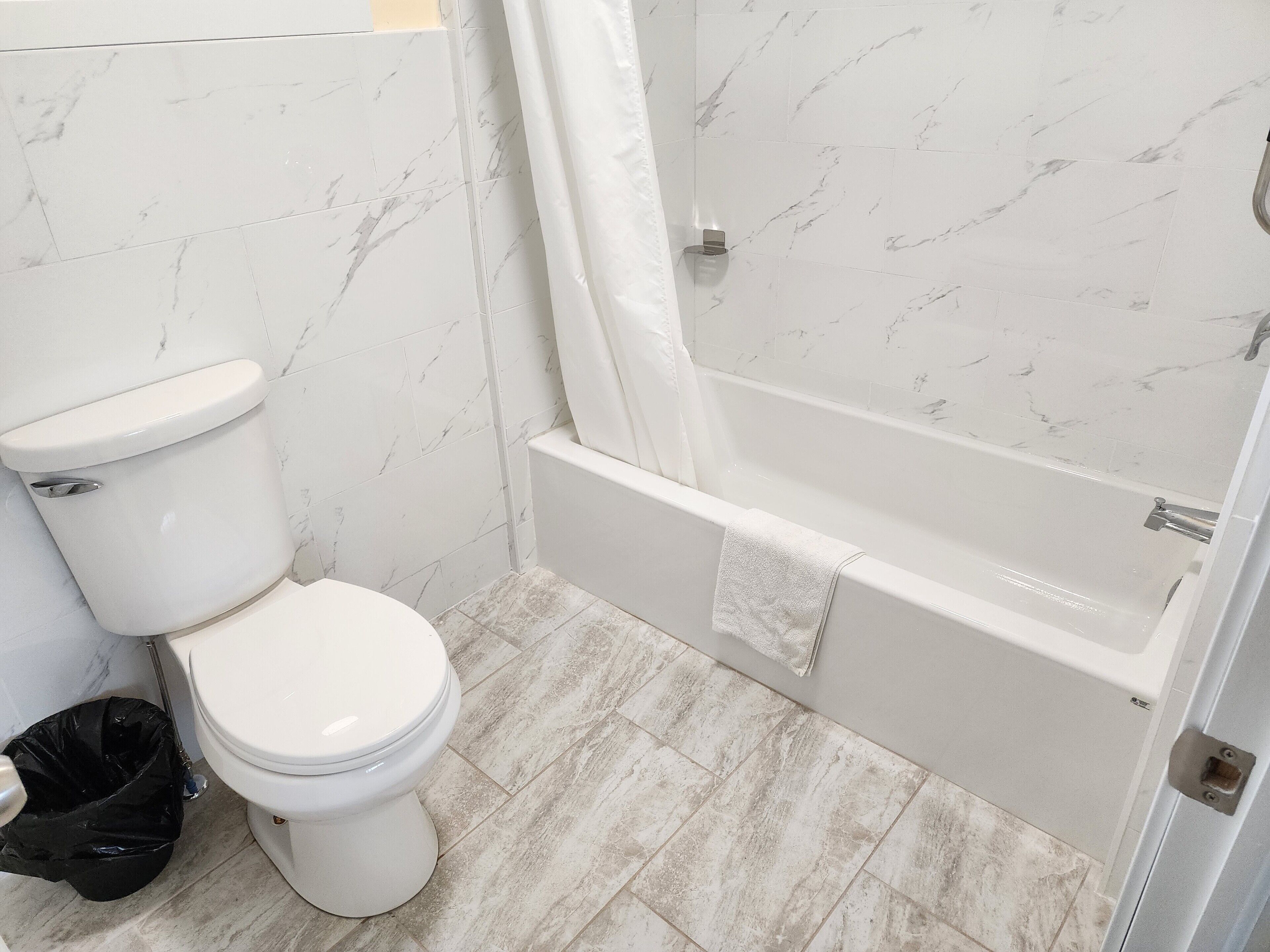 A bathroom with a toilet, a bathtub, and a shower curtain.