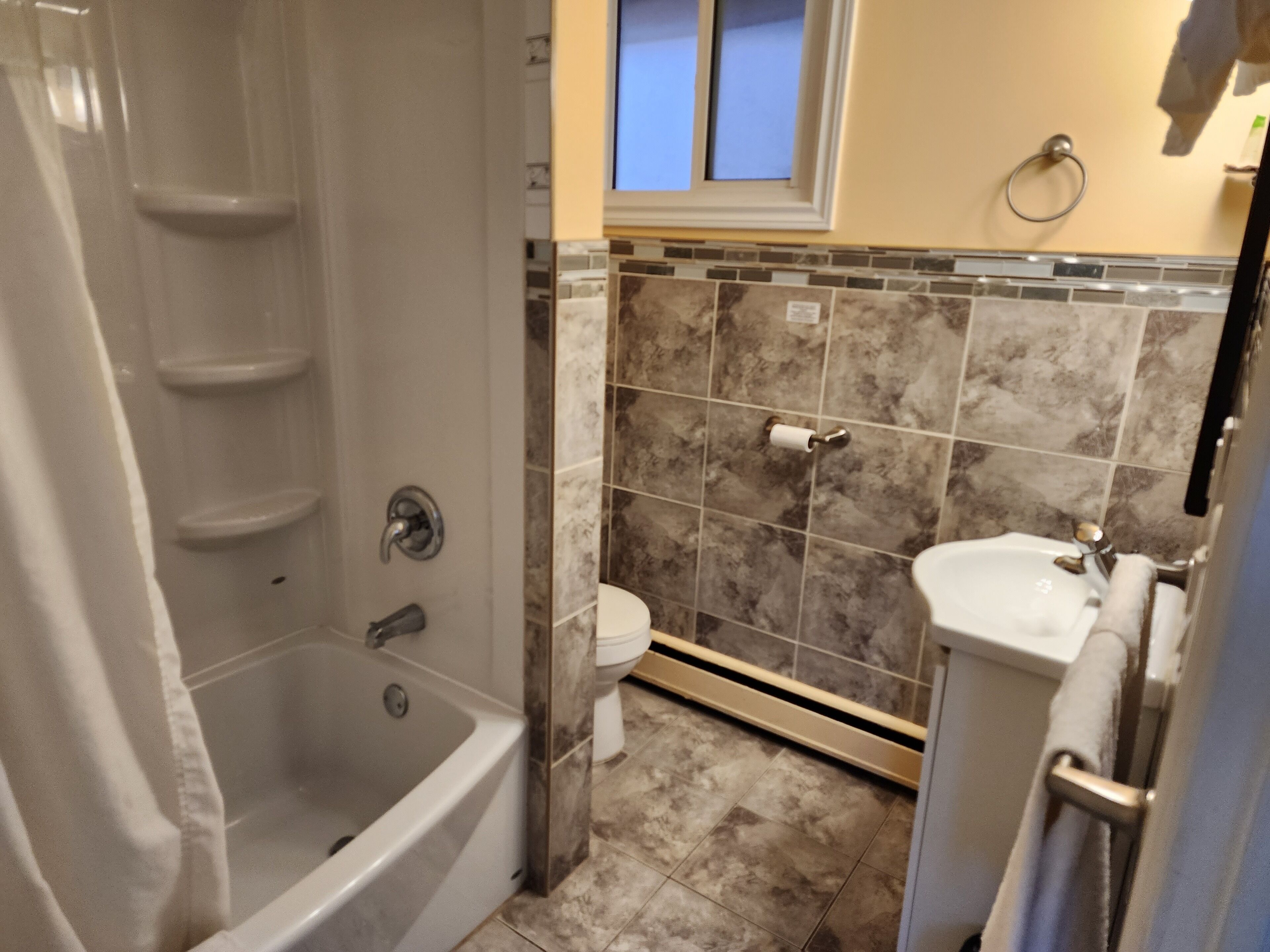 Une salle de bain avec une baignoire, des toilettes et un lavabo.