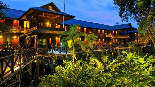 A two-story building with a balcony and a covered walkway over water. - Mulu Marriott Resort (Mulu)
