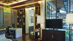 A modern hotel room with a large TV, a desk, a sofa, and a bookshelf. - Mulu Marriott Resort (Mulu)